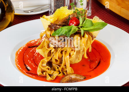Italienische Lasagne mit Tomaten und Gemüse und Sauce auf einem weißen Teller Stockfoto