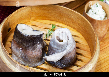 Geschirr, Holz Cup mit gedünstetem Fisch, Salat, Besteck Stockfoto