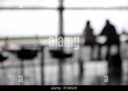 Paar im Café am Flughafen außerhalb des Fokus Stockfoto