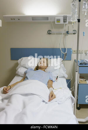Frau, 35-40 Jahre alt, sediert und liegen im Krankenhausbett nach Operation. Stockfoto