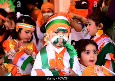 Rajasthan, Indien. 25. Januar 2016. Indische Kinder malen die Trikolore der indischen Flagge auf ihrem Gesicht und erhöhen die Nationalflagge am Vorabend der Republik Day Feierlichkeiten in Rajasthan, Indien. © Shaukat Ahmed/Pacific Press/Alamy Live-Nachrichten Stockfoto