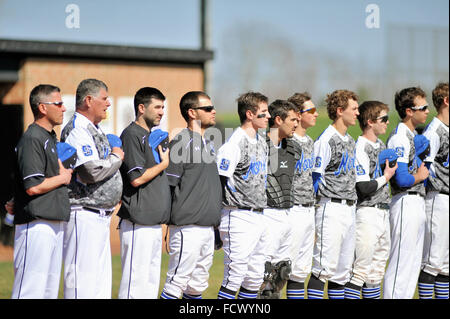 Spieler und Trainer einer High School Baseball Team während der Nationalhymne vor dem Start eines Spiels. USA. Stockfoto