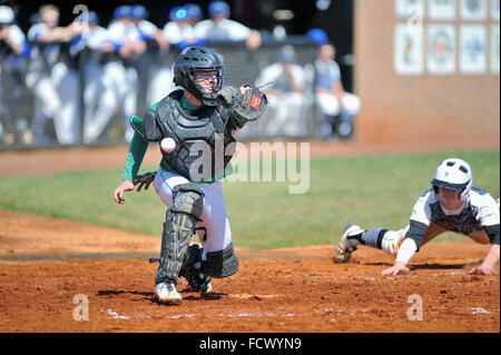 Ein High School Catcher ist nicht in der Lage, eine von der ersten Basisspieler werfen als Base Runner, basierend auf der dritten Base in der Lage ist. USA. Stockfoto