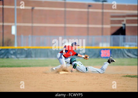 High School Base Runner Folien sicher in die zweite Basis mit einem gestohlenen Basis als infielder akzeptiert einen von der Catcher werfen. USA. Stockfoto