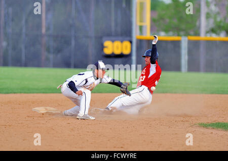 High School Base Runner Folien sicher in die zweite Basis mit einem gestohlenen Basis als infielder akzeptiert einen von der Catcher werfen. USA. Stockfoto