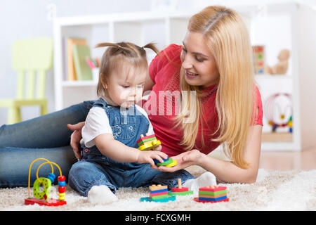 Mutter lehrt ihr Kind, Form und Colur Plaing mit Spielzeug zu unterscheiden. Stockfoto