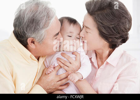 Porträt des alten Liebespaar kümmert sich ein baby Stockfoto