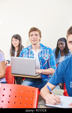Schüler, die Notizen mit Laptop in der Klasse an der Universität Stockfoto