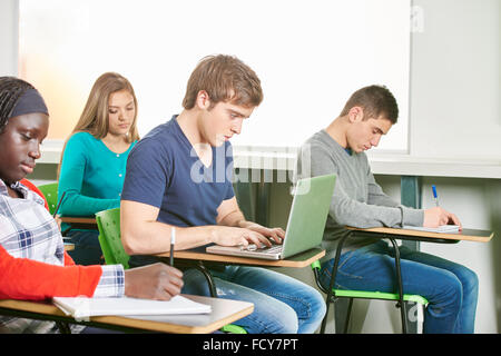 Student nimmt einen Test in seinem Laptop in einem High-School-Klassenzimmer Stockfoto