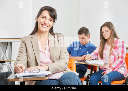 Lehrer, die lächelnd Inhalte in ihrem High-School-Klassenzimmer Stockfoto