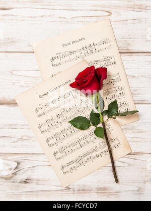 Rote rose Blume und Musik Noten Blatt. Vintage-Stil-Hintergrund Stockfoto