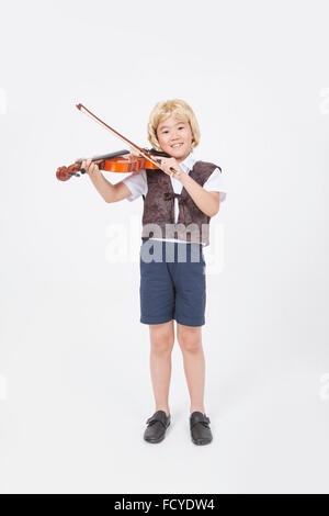 Junge im Stil klassischer Musiker stehen und Violine spielen Stockfoto