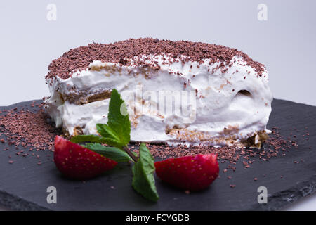 Tiramisu Dessert Kuchen mit Erdbeeren auf schwarzem Schiefer Tablett Stockfoto