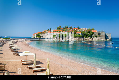 Sveti Stefan Luxus Sand Strand mit Chaiselongue liegen und Sonnenschirme Stockfoto
