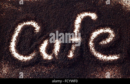 Wort-Café-Hintergrundbeleuchtung in Kaffeesatz Stockfoto