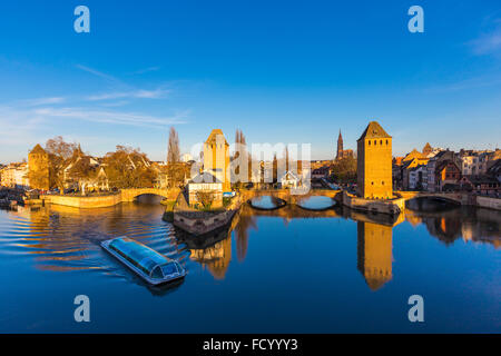 Ausflugsschiff mit Touristen entlang dem Fluss Ill und Rücken Ponts Couverts Brige Petite France-Straßburg Stockfoto