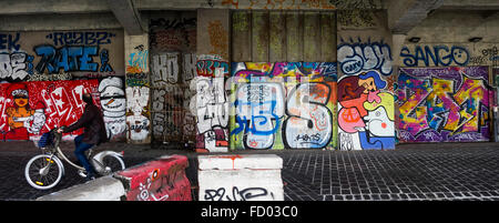 Mann auf Velib vorbei an bunten Unterführung mit Graffiti-Kunst auf eine Betonwand, Austerlitz, Paris, Frankreich. Stockfoto