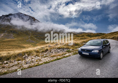 Fahrzeug auf Mountain Road, niedrige Wolken über Piva Plateau und Berge, Durmitor Nationalpark Durmitor, Dinarischen Alpen, Montenegro Stockfoto