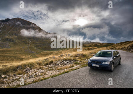 Fahrzeug auf Mountain Road, niedrige Wolken über Piva Plateau und Berge, Durmitor Nationalpark Durmitor, Dinarischen Alpen, Montenegro Stockfoto