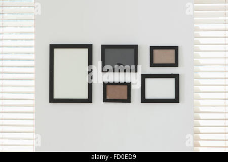 Leere Rahmen angeordnet und auf einer weißen Wand fixiert Stockfoto