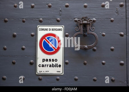 Alte Metall wundervollen und No Parking Schild an den schwarz lackierten Holztor fixiert mit Nieten in Bergamo, Lombardei, Italien. Stockfoto