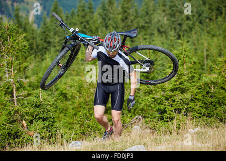 Radfahrer mit seinem Mountainbike auf einem steil bergauf Stockfoto