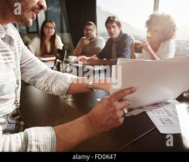 Nahaufnahme der Hände des Jünglings Businessplan, Kollegen zu erklären. Kreative Menschen treffen im Konferenzraum. Stockfoto