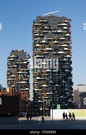 Menschen passieren die Wohntürme Bosco Verticale (vertikale Wald) im Stadtteil Porta Nuova in Mailand, Lombardei, Italien. Stockfoto