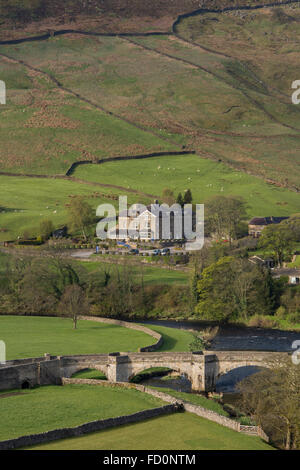 Yorkshire Dales Blick auf Brücke über Fluß Wharfe & Devonshire fiel Hotel auf sanften grün, Hügeln jenseits - Burnsall, England, GB, UK. Stockfoto