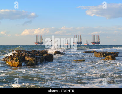 Meer-Station der Gasproduktion. Bohrplattformen im Meer bei Sonnenuntergang vor blauem Himmel Stockfoto