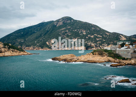 Blick auf felsigen Küste bei Shek O und D'Aguilar Peak, von Tai Tau Chau, auf Hong Kong Island, Hongkong. Stockfoto