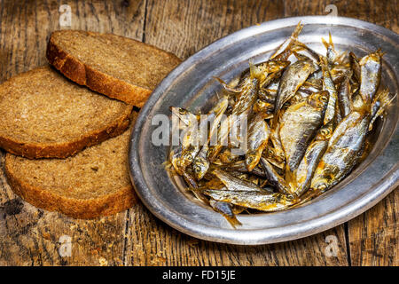 Silberplatte mit leckere Sardellen und Brot auf alten Holztisch Stockfoto