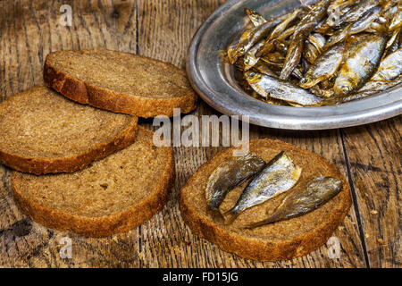 Roggenbrot mit leckere Sardellen auf alten Holztisch Stockfoto