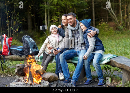 Familie mit Smartphone unter Selfie nahe am Lagerfeuer Stockfoto