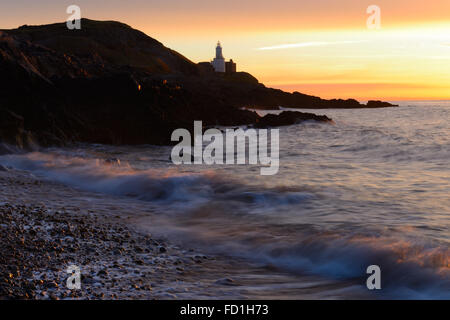 Wellen am Kiesstrand bei Sonnenaufgang über Mumbles Lighthouse, Gower Wales - einer ruhigen und malerischen frühmorgens Szene zu inspirieren und zu erinnern. Stockfoto