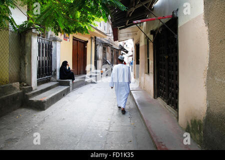 Stone Town, Sansibar, Tansania - 1. Januar 2016: Erwachsener Mann in traditioneller Kleidung in Zanzibar Gasse Stockfoto