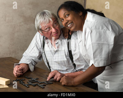 Rentner im Pflegeheim Domino spielen Stockfoto