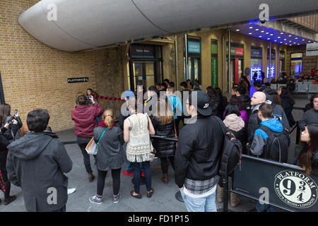 Eine Schlange von Menschen warten auf Gleis 9 3/4 an der Kings Cross station Stockfoto