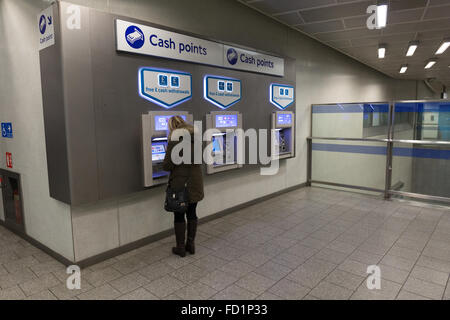 Eine Frau eine ATM-Bank-Automaten am Kings Cross u-Bahnstation Stockfoto