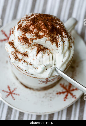 Eine Tasse heiße Schokolade mit Schlagsahne Sahne und Kakaopulver Stockfoto