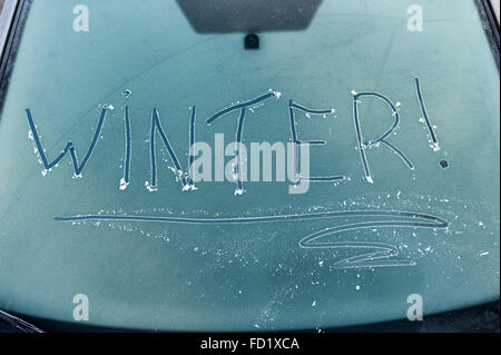 Das Wort Winter geschrieben auf einem gefrorenen Auto Windschutzscheibe Stockfoto