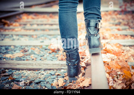 Schwarze Lederstiefel entlang alter Bahngleise. Vintage durchtrainierten Bild. Stockfoto