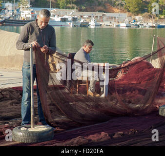 Spanische Fischer reparieren ihre Netze. Stockfoto