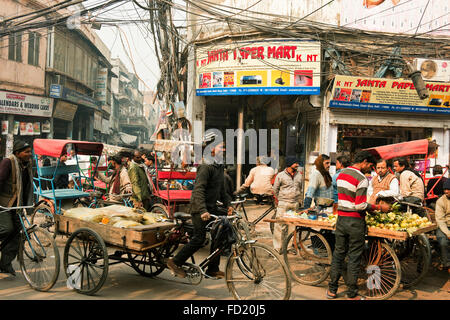 A Straßenszene in Chandni Chowk Markt, Alt-Delhi, Indien mit Rikscha und Fahrer und Straße Verkäufer auf einer belebten Straße Stockfoto