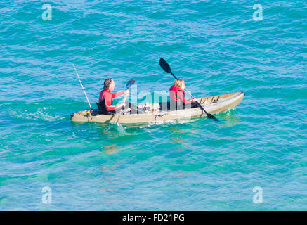 Kaukasische applying paar Kajakfahren im Meer, UK Stockfoto