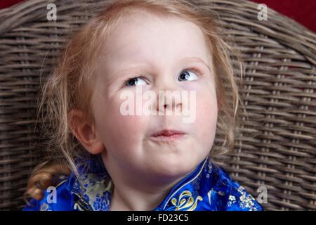 Kleines Mädchen hart in Studioportrait denken. Lustig und natürlichen Ausdruck. Stockfoto