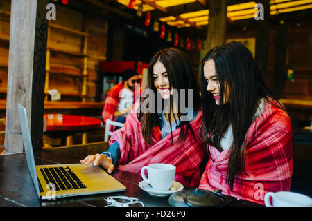 zwei Mädchen beobachten etwas in laptop Stockfoto