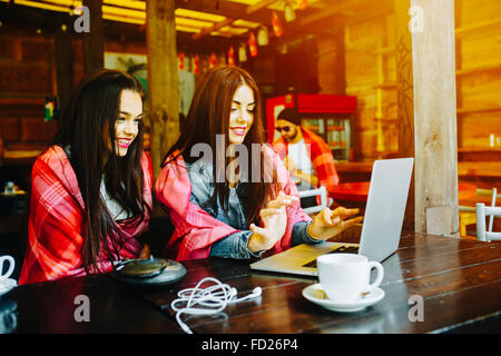 zwei Mädchen beobachten etwas in laptop Stockfoto