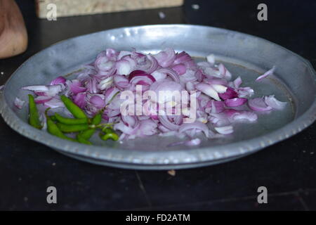 Mumbai, Indien - 28. Oktober 2015 - Frau schneiden Chili und Zwiebeln auf einem traditionellen schneiden Hocker in indischen Küche Stockfoto