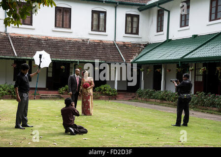 Ein hinduistisches Brautpaar, das von einem Hochzeitsfotografen und seinen Assistenzen in den Peradeniya Botanical Gardens, 5,5km westlich von Kandy in, fotografiert wurde Stockfoto